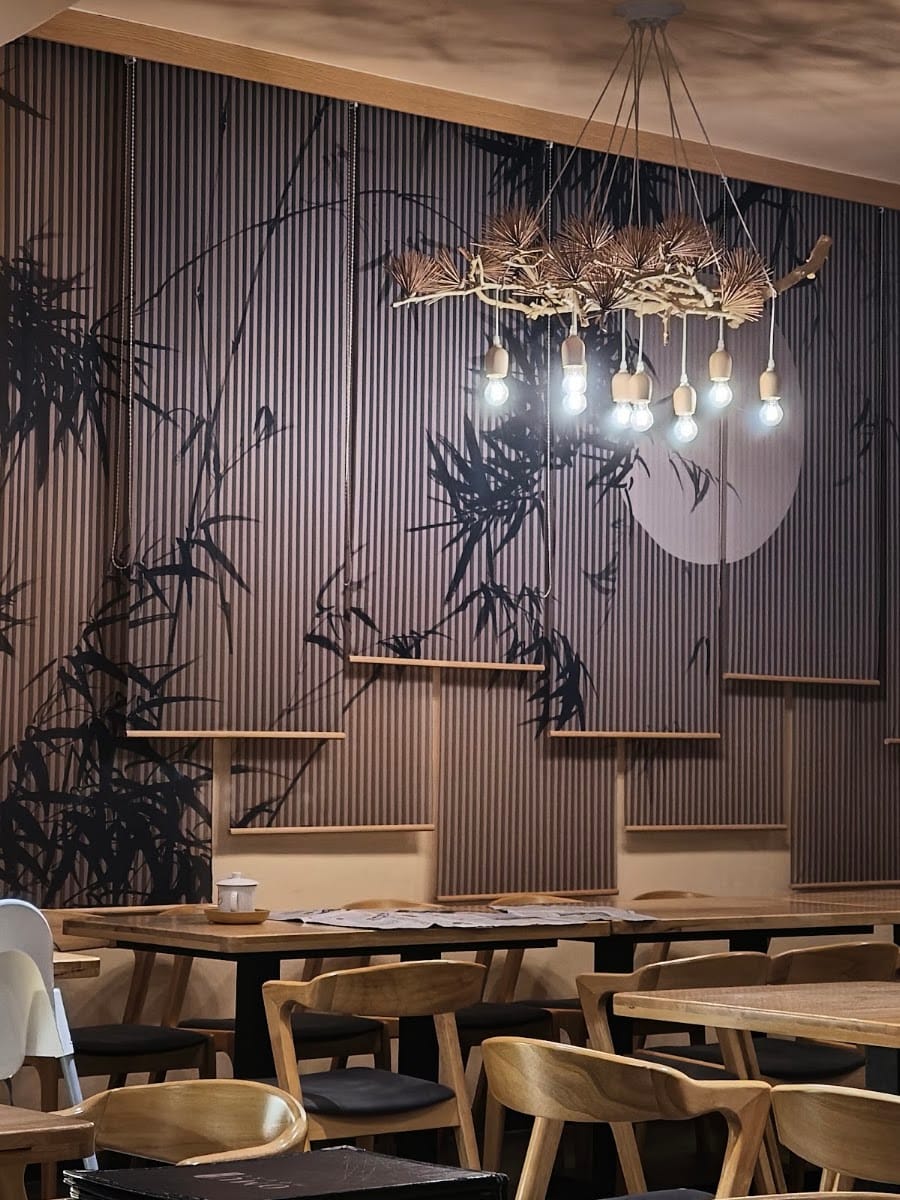 Dining room with bamboo mural wall and a branch chandelier