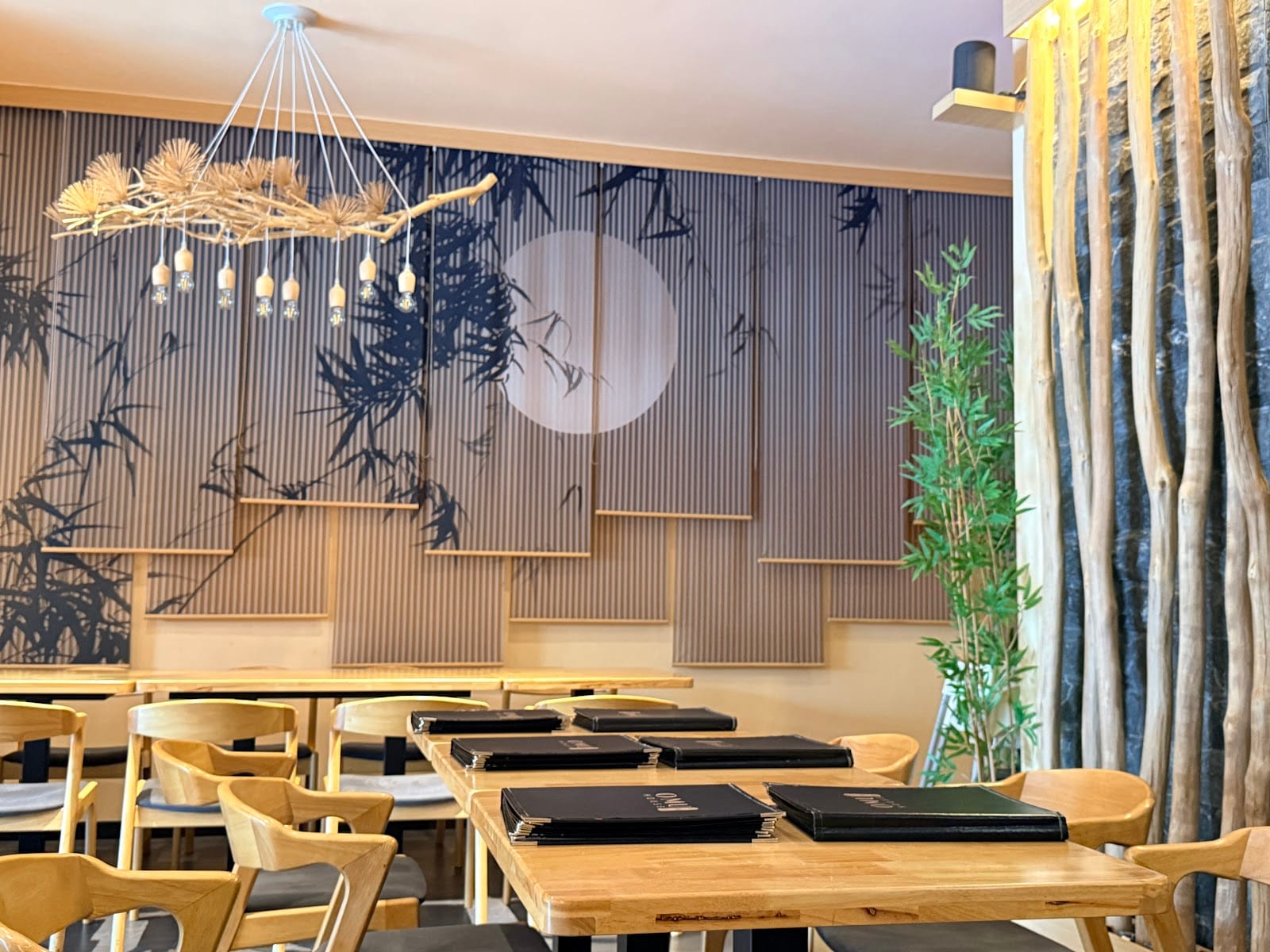 Dining tables set with menus under the bamboo mural wall