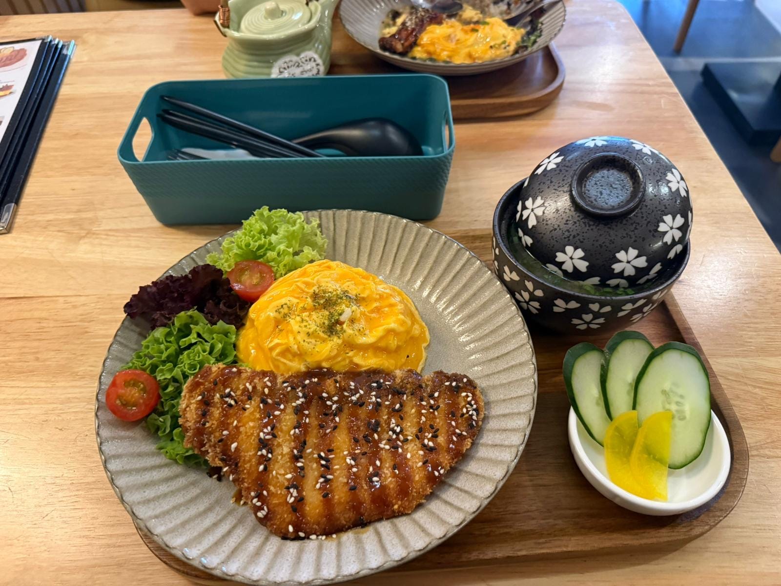 Sesame-glazed pork cutlet with omurice and salad, plated at the table